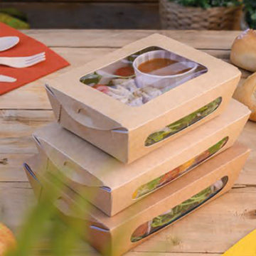 Contenitori cibo asporto cartone avana con finestra sul coperchio, chiusi, diverse misure impilate e piene su tavola di legno